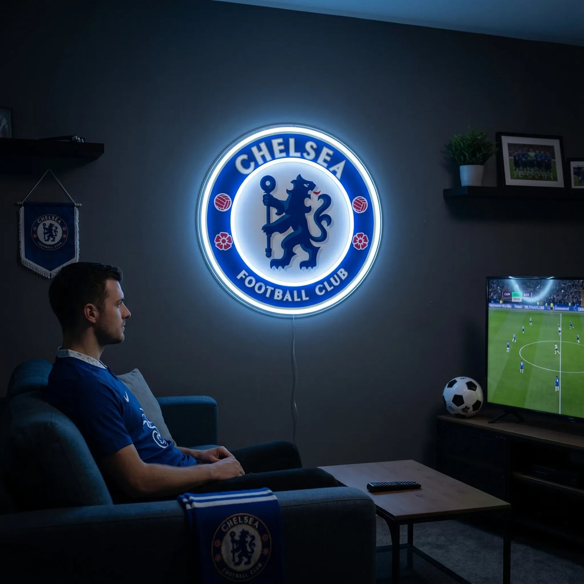 A man holding a large circular Chelsea Football Club crest LED neon sign featuring the iconic ceremonial lion rampant regardant holding a staff glowing in a vibrant blue and bright white light