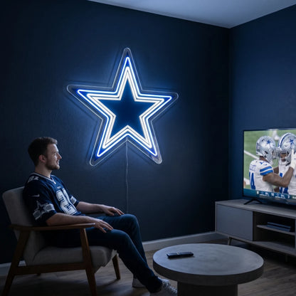 A man holding a large star-shaped Dallas Cowboys NFL football team logo LED neon sign featuring the iconic blue and white layered star design glowing in vibrant royal blue and bright white light