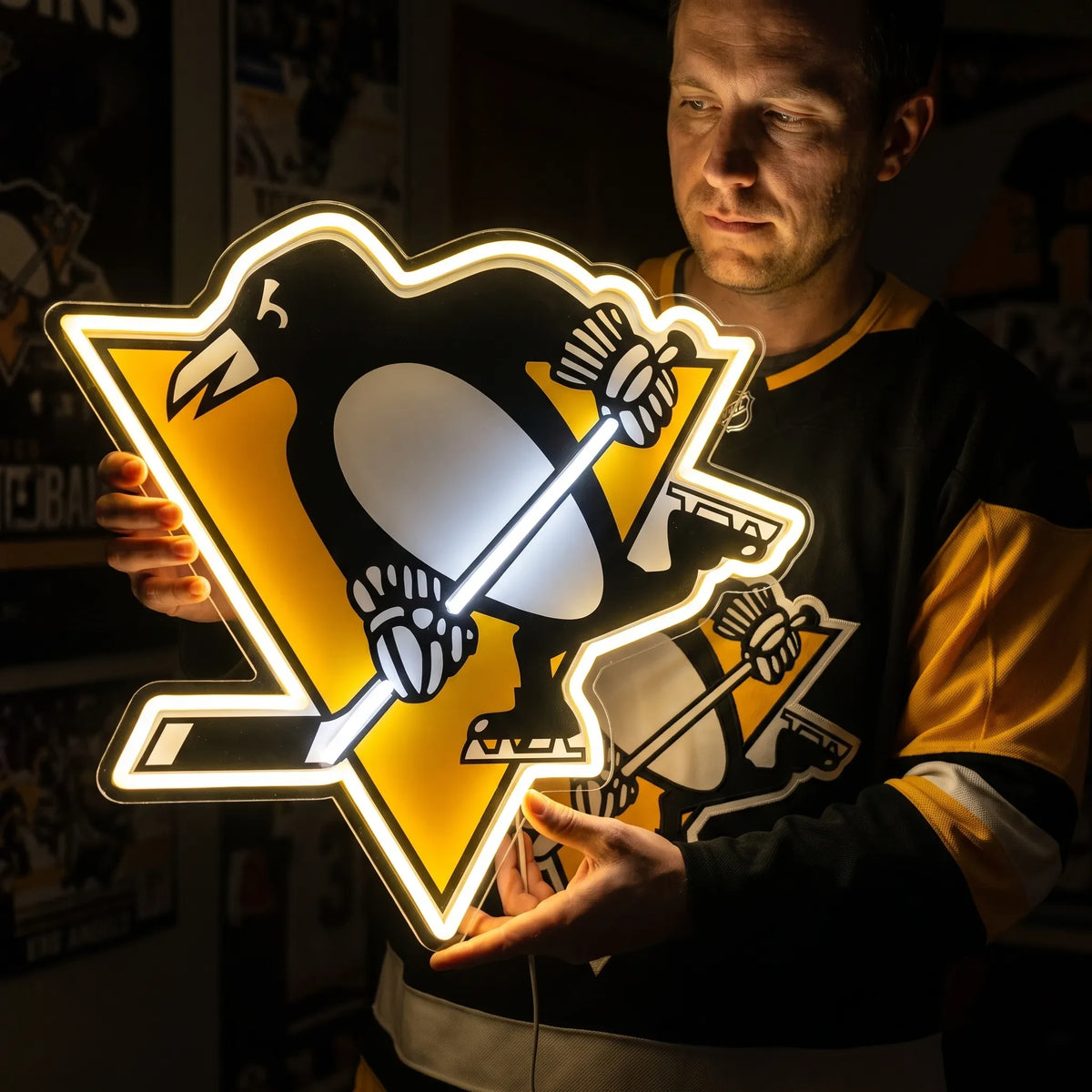 A man holding a large Pittsburgh Penguins NHL ice hockey team logo LED neon sign