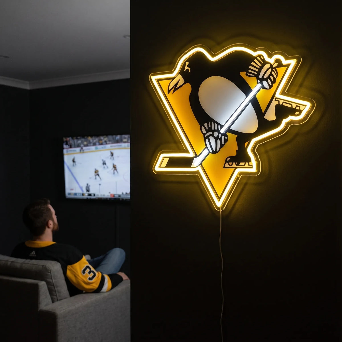 A man holding a large Pittsburgh Penguins NHL ice hockey team logo LED neon sign