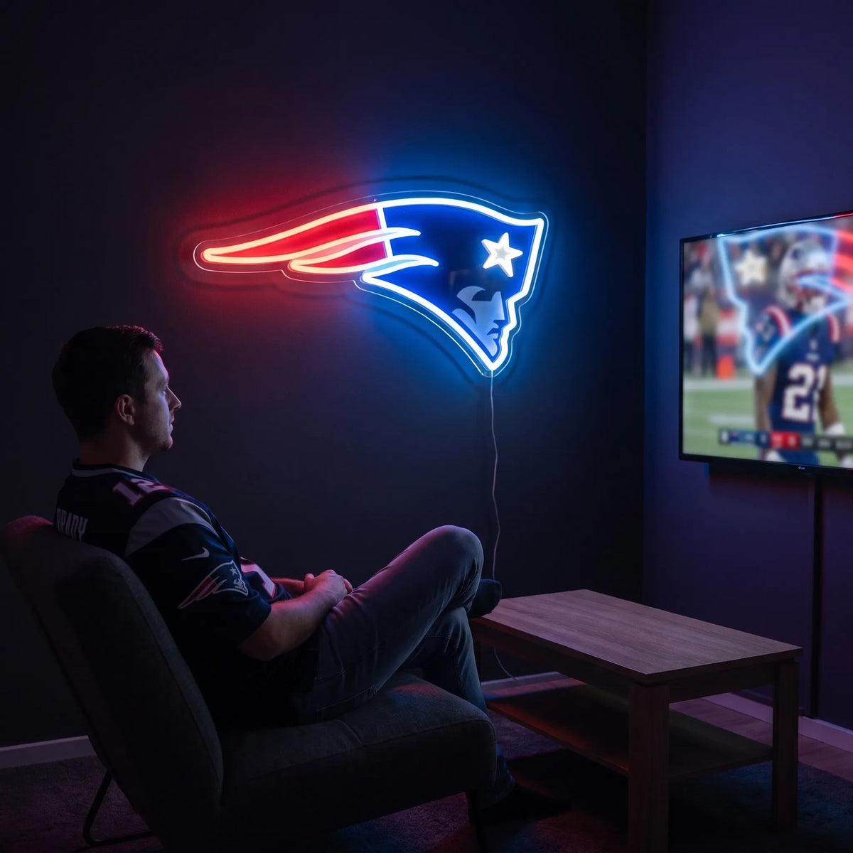 A man holding a large custom-shaped New England Patriots NFL football team logo LED neon sign featuring the Flying Elvis patriot head design with a white star glowing in vibrant red, white, and deep blue light