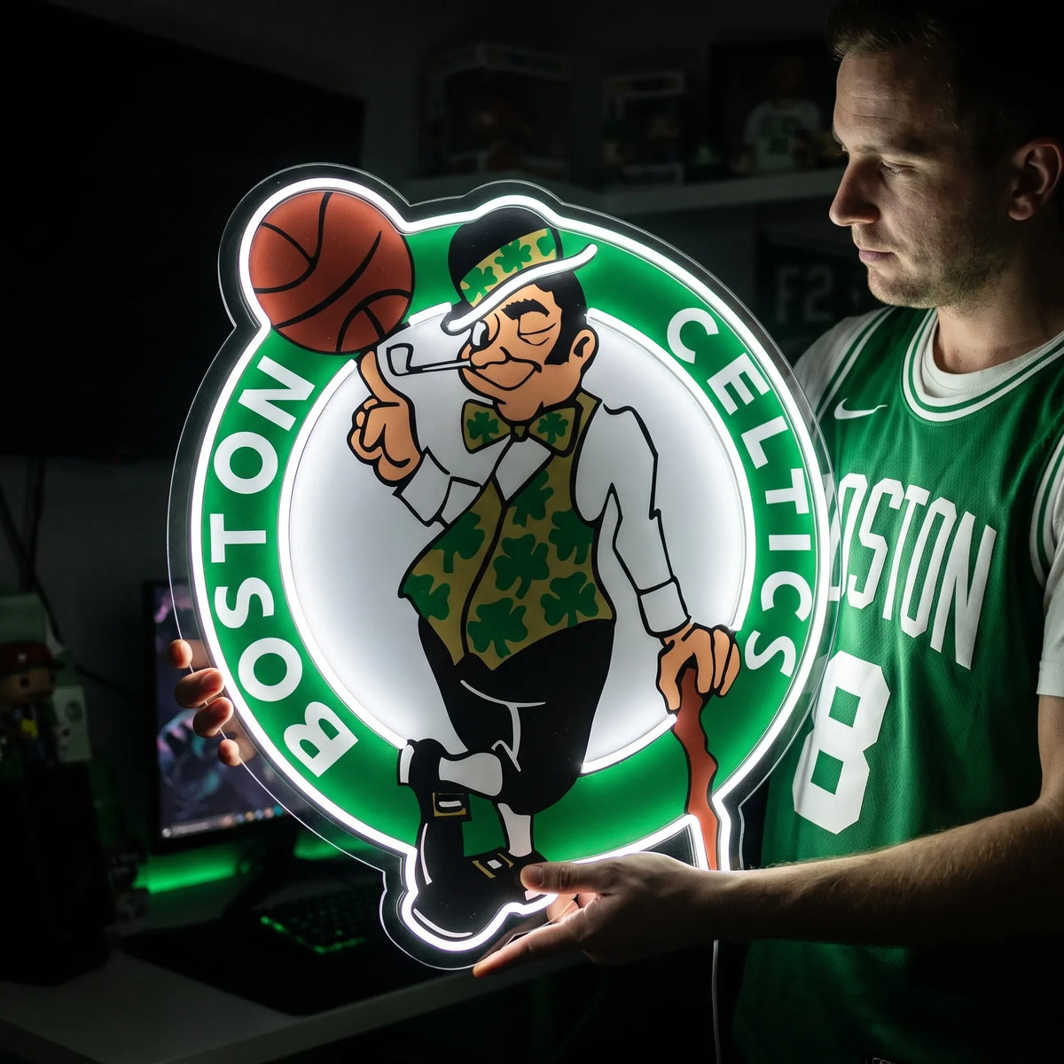 A man holding a large Boston Celtics NBA basketball team logo LED neon sign