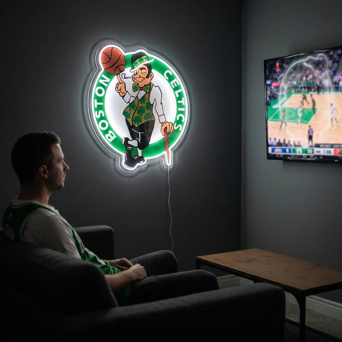 A man holding a large Boston Celtics NBA basketball team logo LED neon sign