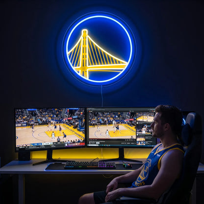 A smiling woman holding a round glowing blue and yellow Golden State Warriors NBA basketball team LED neon sign featuring the Bay Bridge logo